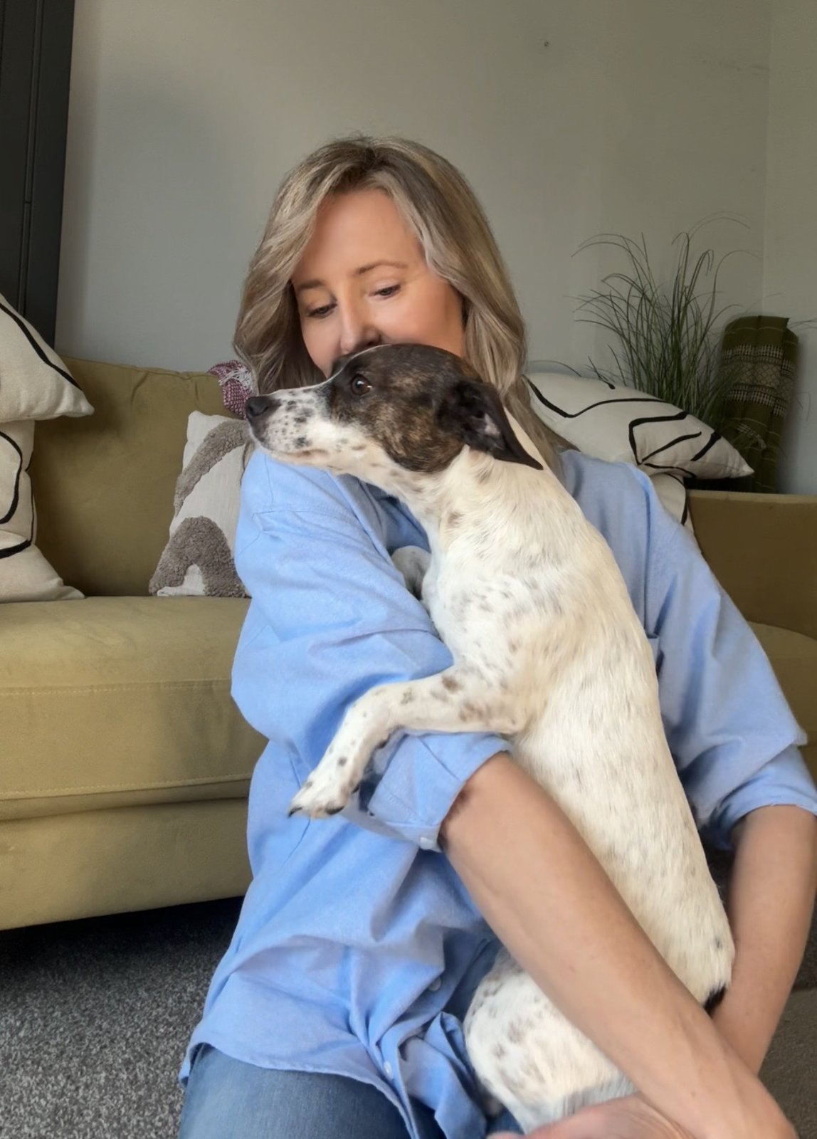 A K9 4 Life customer cuddling her Jack Russell on the sofa — a quiet moment with her dog.